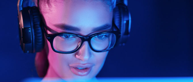 female pro gamer playing video game, wearing headset